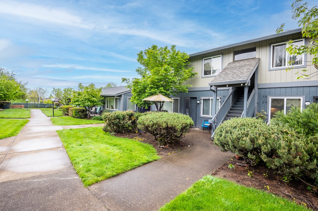 a blue house with a sidewalk in front of it