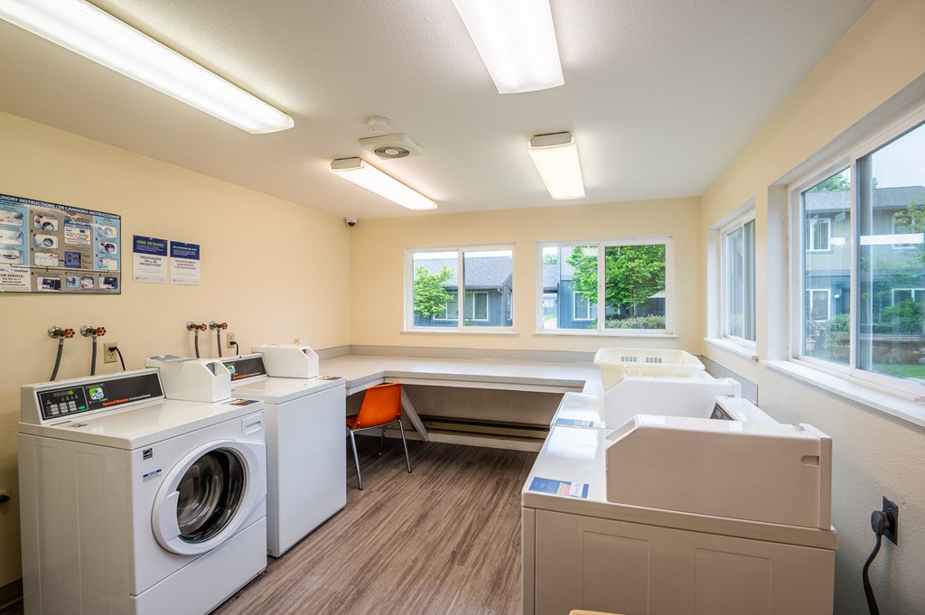 a laundry room with washer and dryer and a sink and a window