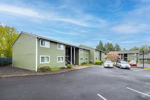 our apartments are located on the corner of a parking lot with cars
