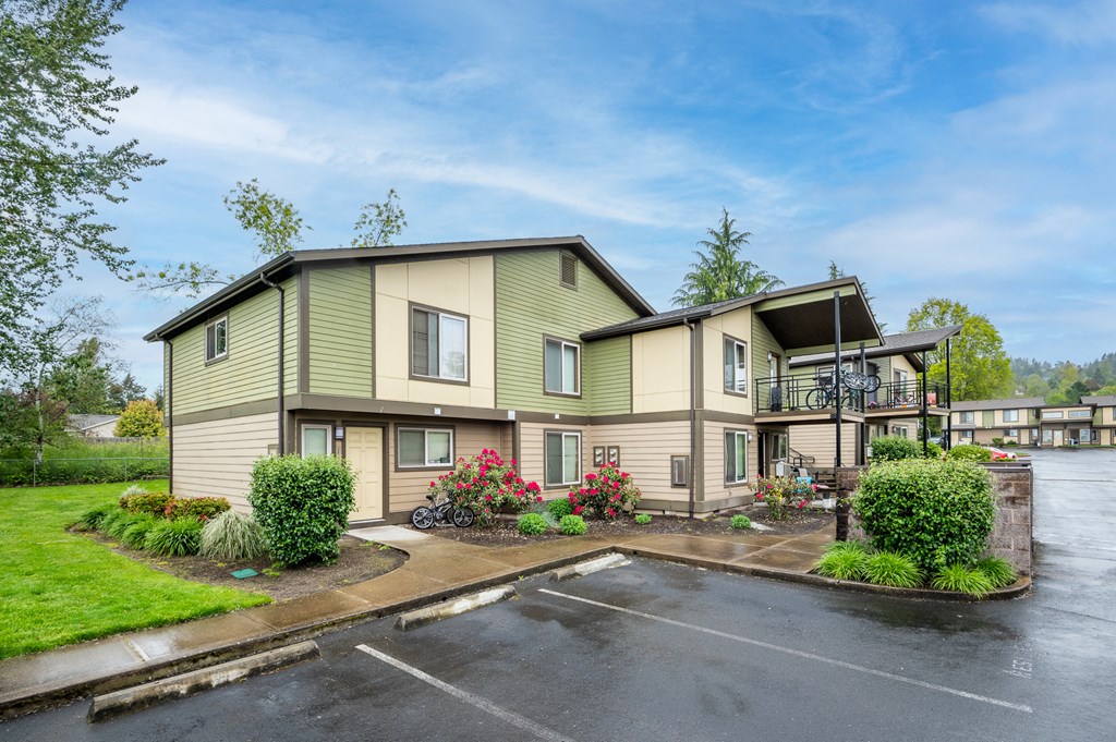 the view of a two story apartment building with a parking lot