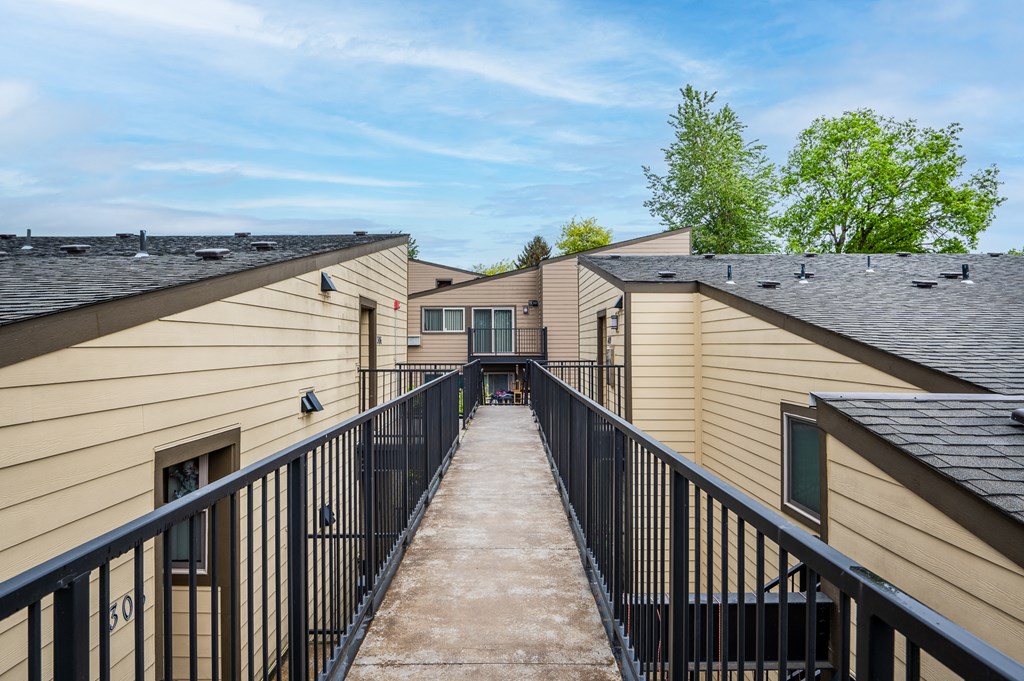 the view from the balcony of an apartment building with a walkway