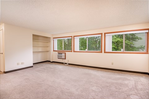 the living room of a home with a carpeted floor and windows