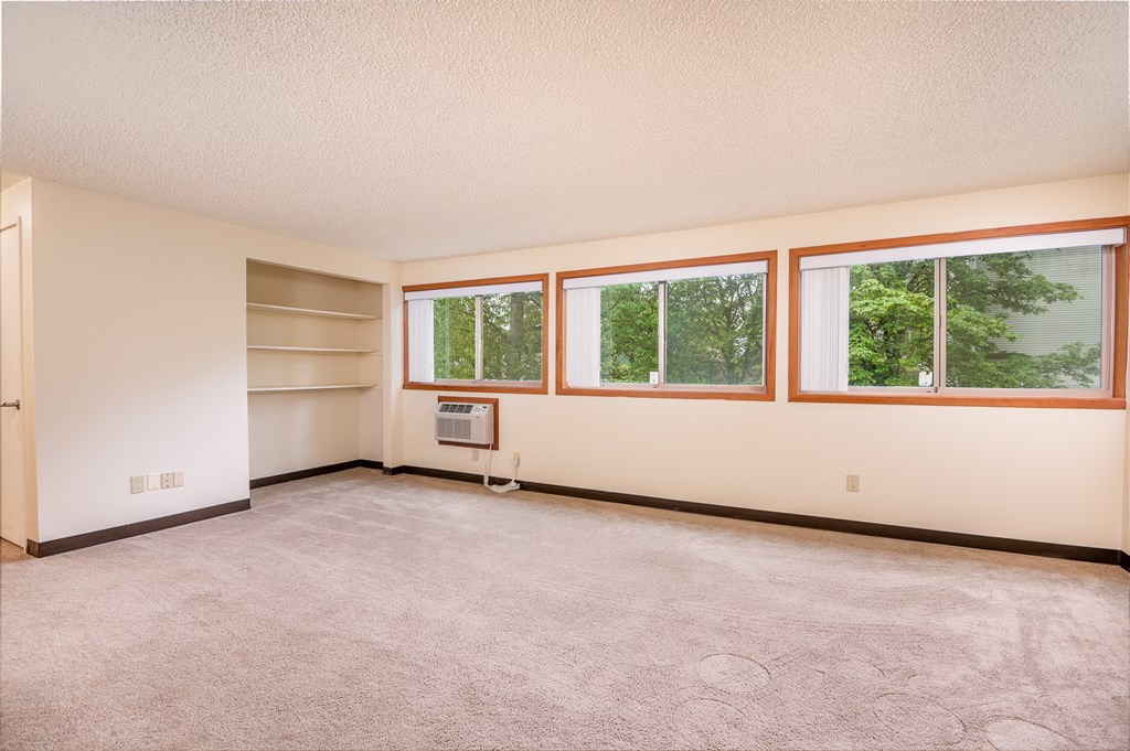 the living room of a home with a carpeted floor and windows