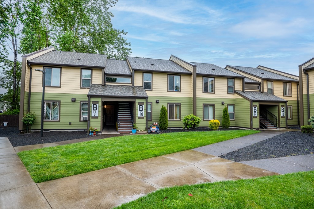 a row of houses with a sidewalk and grass