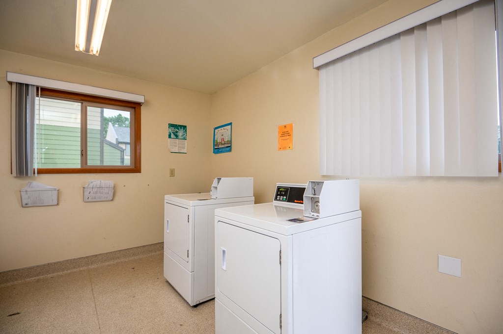 a laundry room with washers and dryers and a window