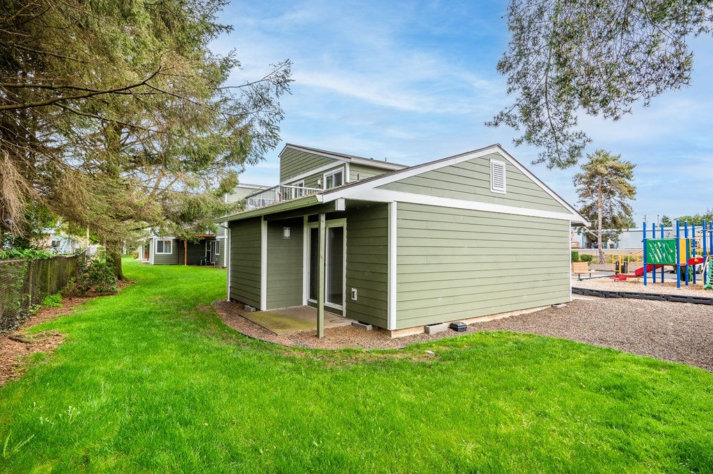 a green house with a yard and a playground