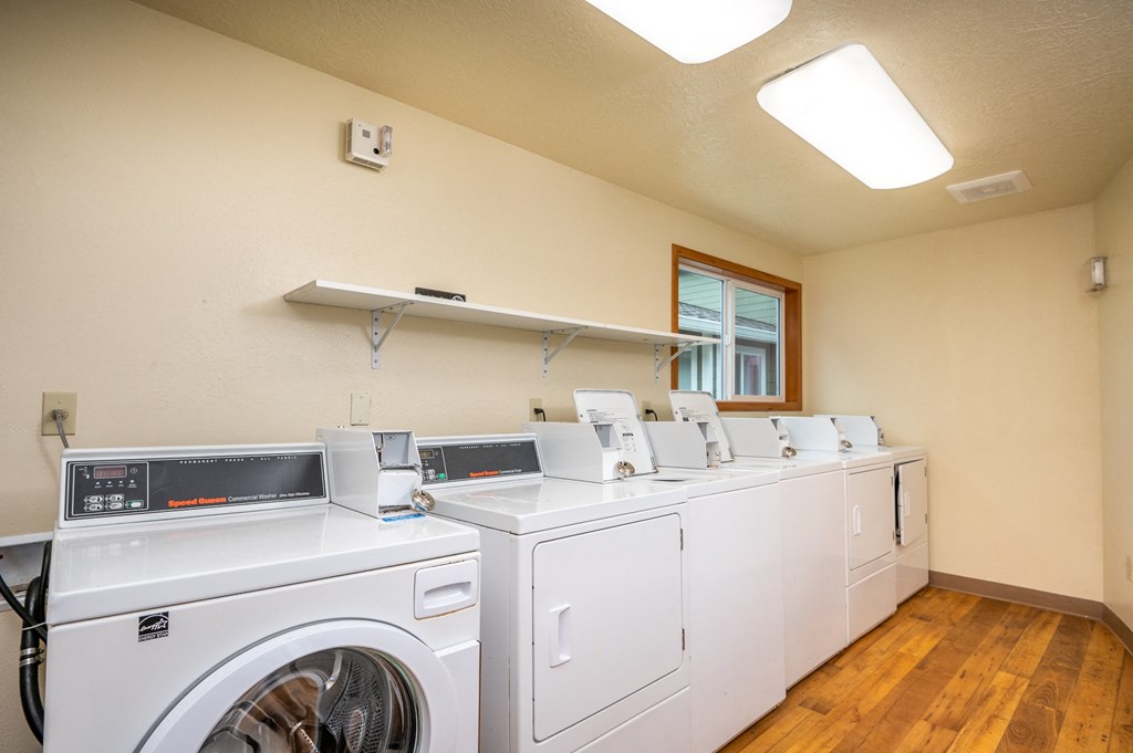 a washer and dryer room with washing machines and a window