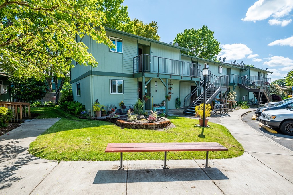 a park bench in front of an apartment building