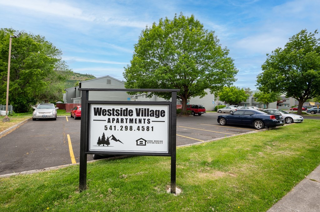a parking lot with a sign in the grass