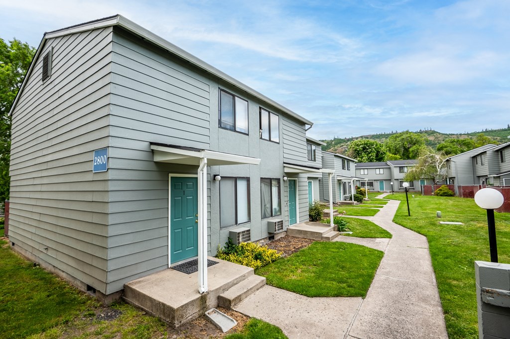 a row of houses with a sidewalk in front of them