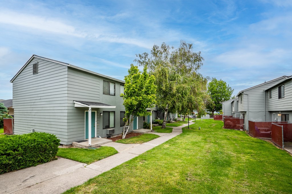 a row of houses in a neighborhood with sidewalks and grass