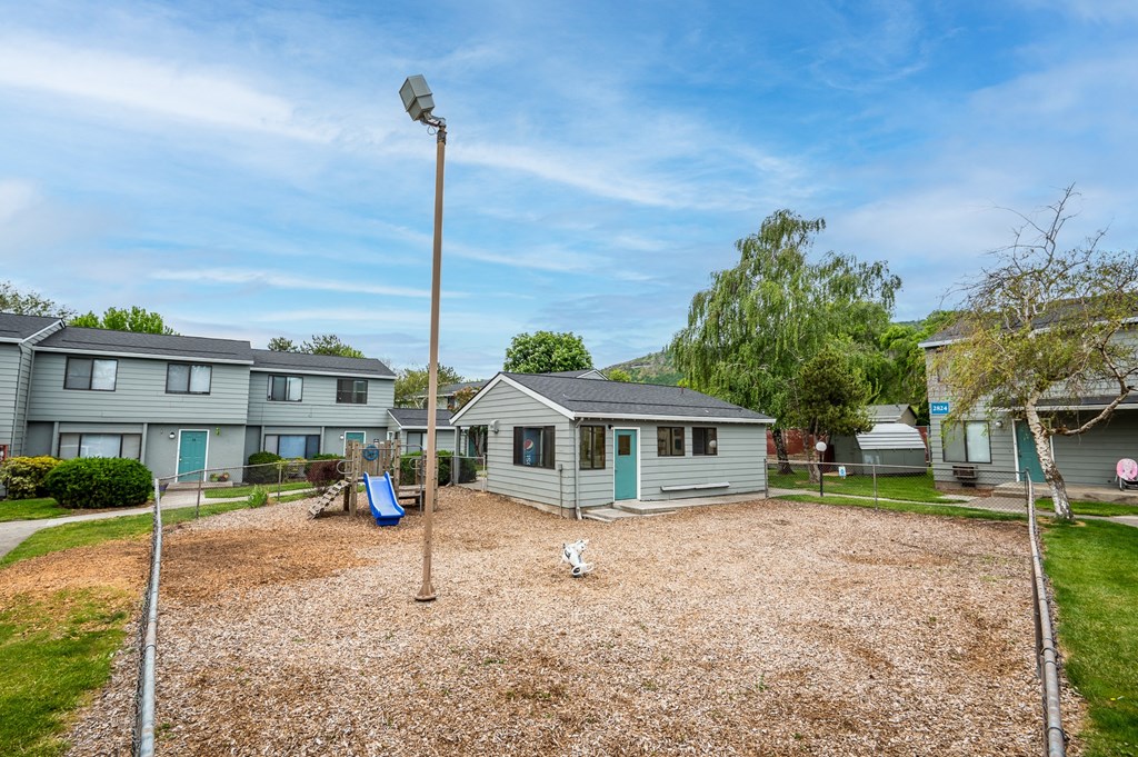 the backyard of a house with a yard and a dog in front of it