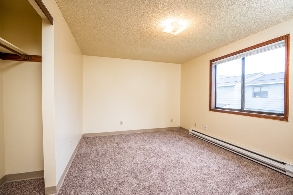 an empty living room with carpet and a large window