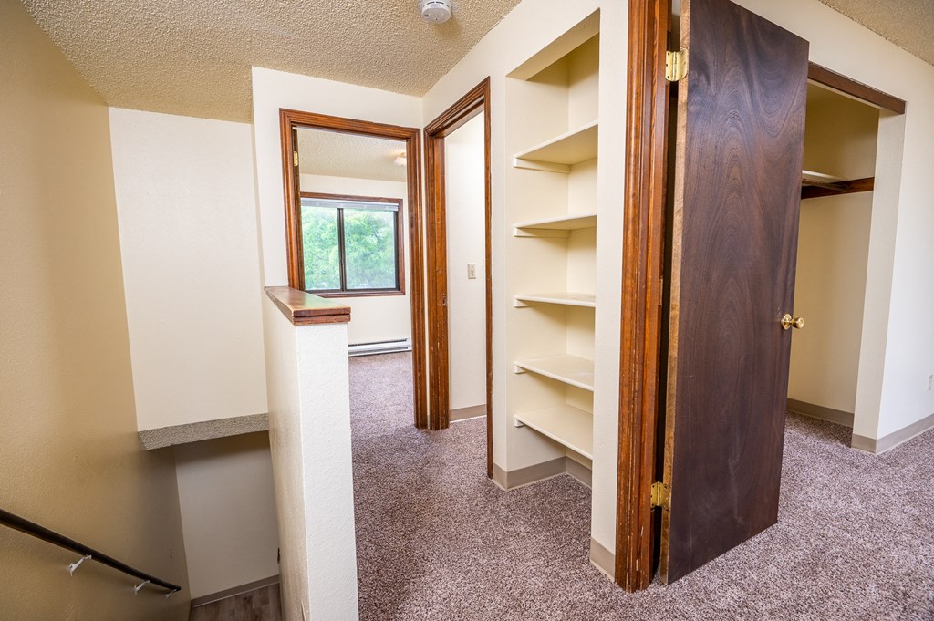 a bedroom with a closet and a window and a door to a closet