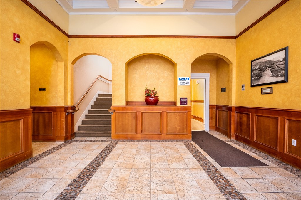 the lobby of a building with yellow walls and a staircase