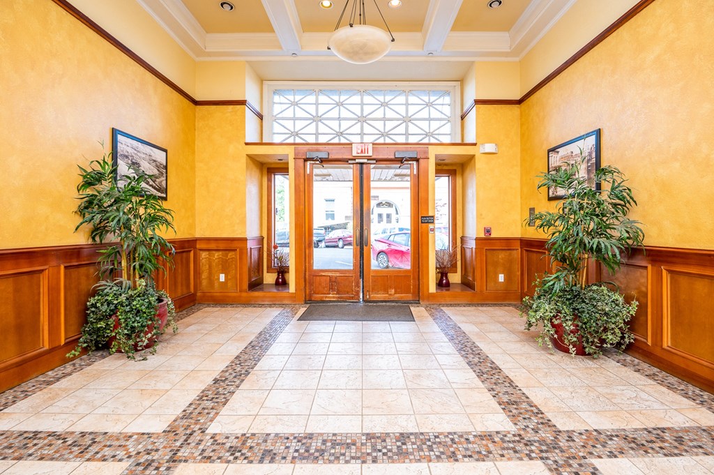 a lobby with doors and plants and a large window