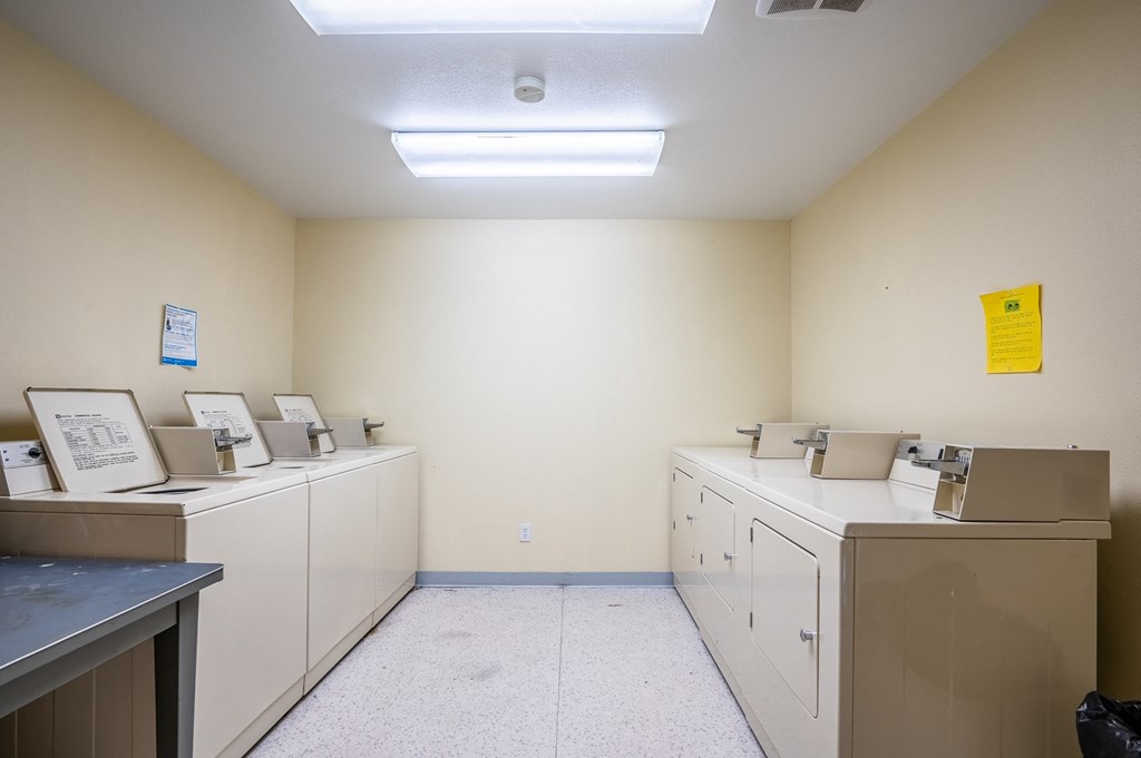 a laundry room with washers and dryers and a sign on the wall