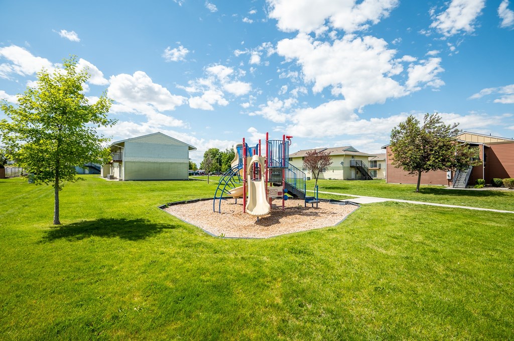 a playground with a swing set in the middle of a yard