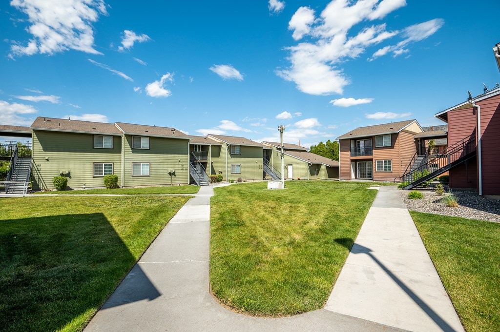 a row of houses on a sidewalk with grass