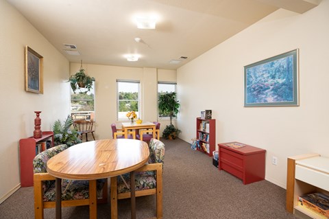 a living room with a table and chairs in the center