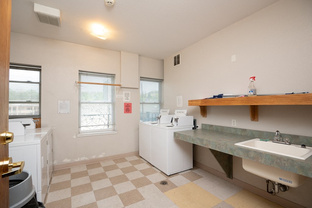 a kitchen with a sink and a washing machine and a window