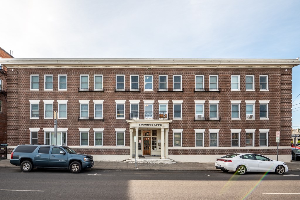 a large brick building with cars parked in front of it