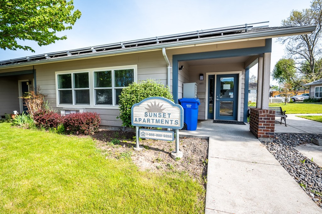 a sunset apartments sign in front of a building