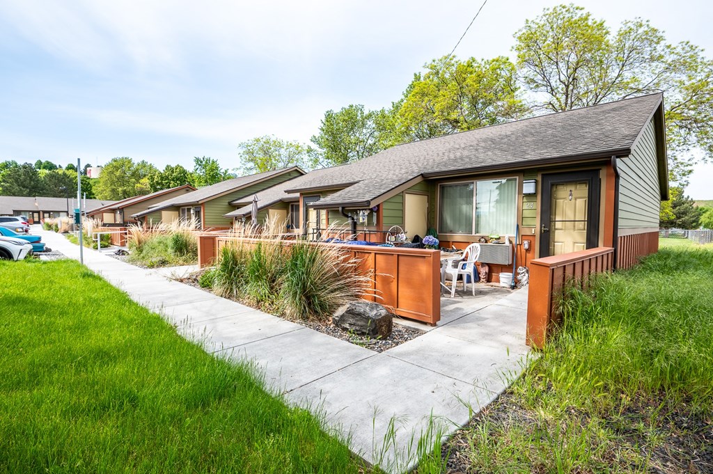 a row of bungalows with a sidewalk and grass