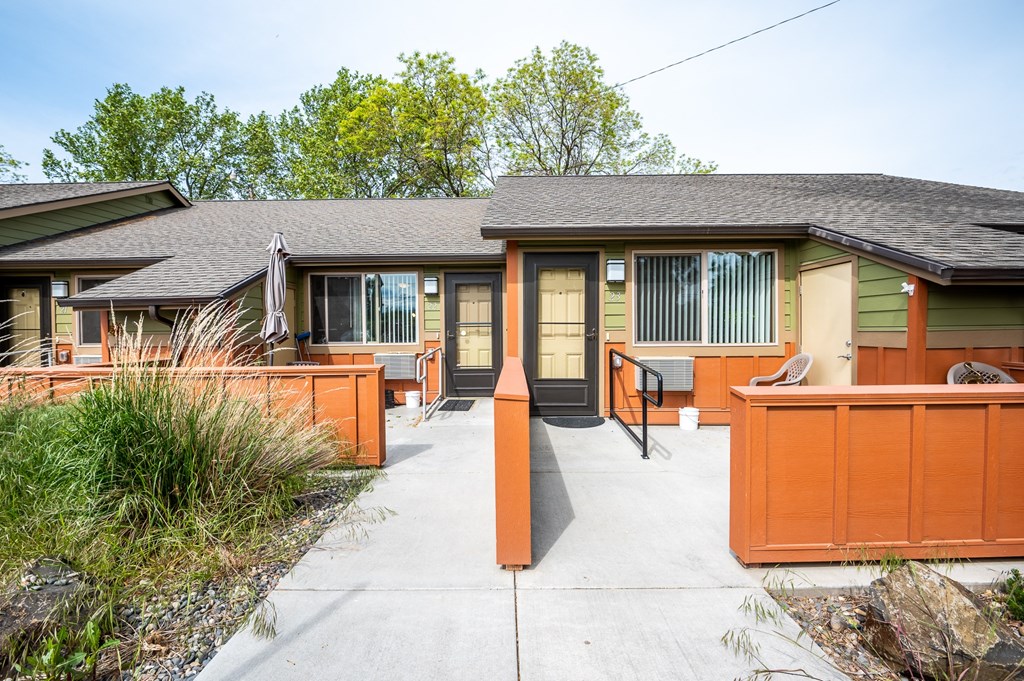 the front of a house with a concrete walkway and a deck with a patio