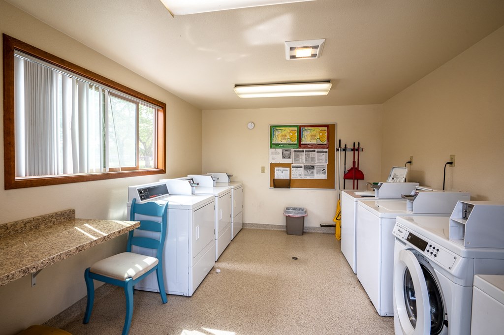 a laundry room with washes and dryers and a window