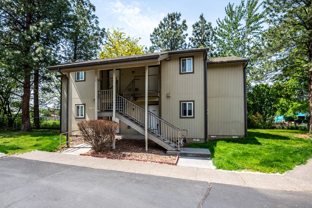 the front of a house with stairs and a driveway