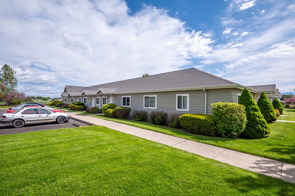 a gray house with a car parked in front of it