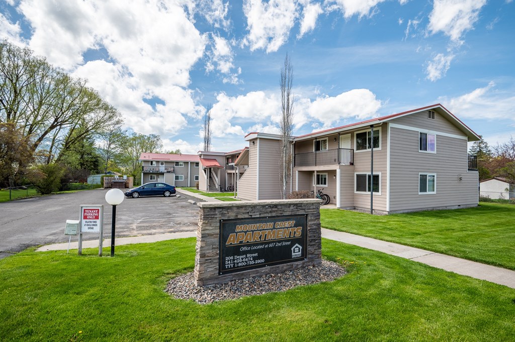 an apartment building with a sign in front of it