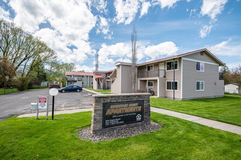 an apartment building with a sign in front of it