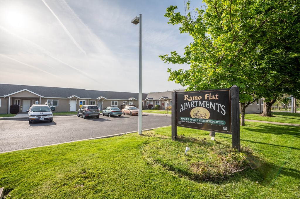 a sign for romp flat apartments in front of a parking lot