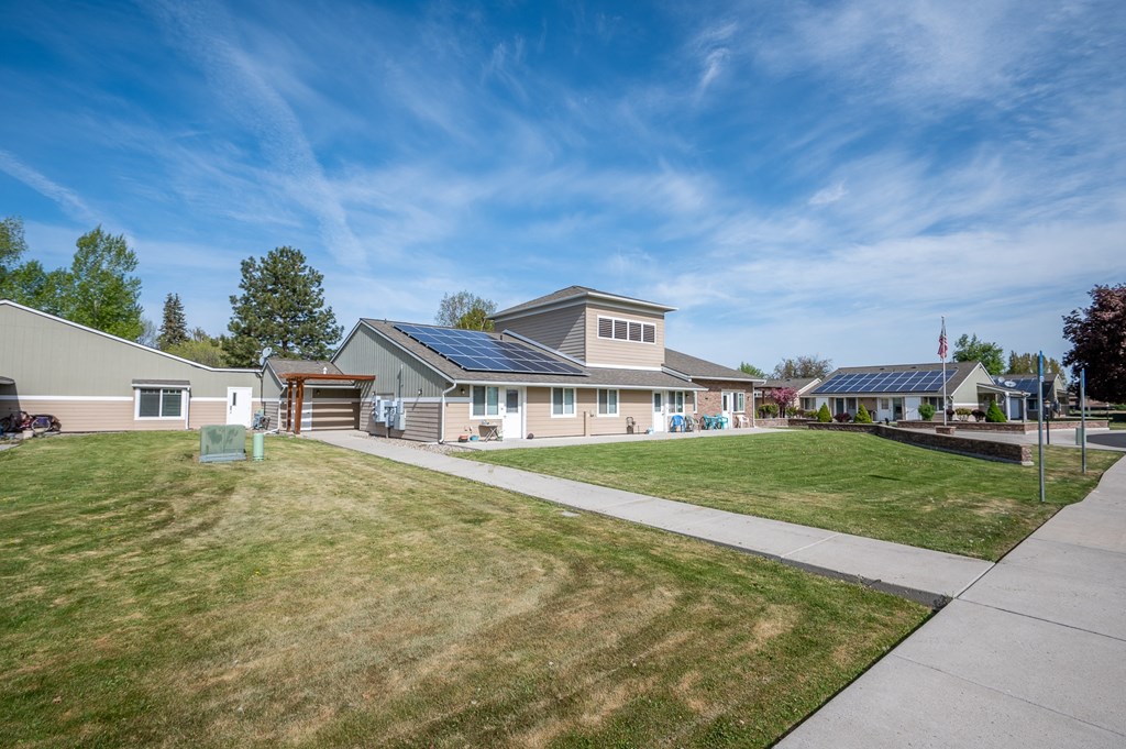 a house with solar panels on the roof and a sidewalk
