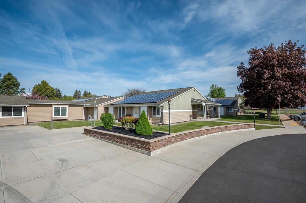 a street with a row of houses with solar panels on the roofs