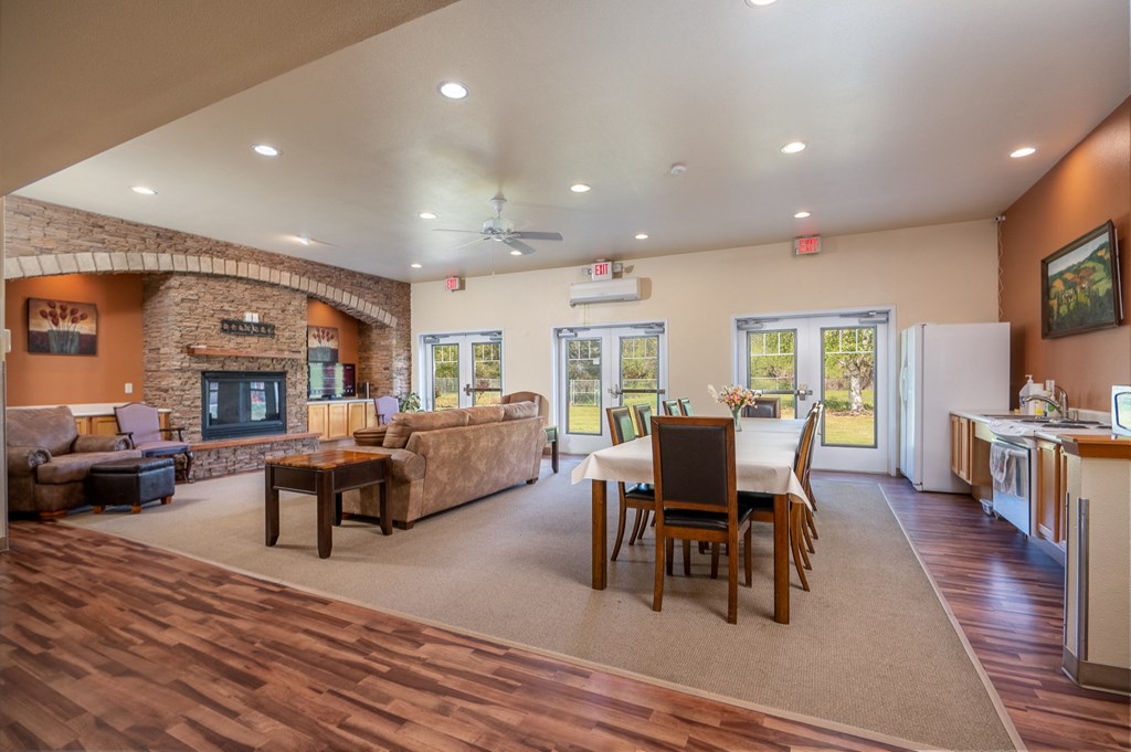 the view of a living room with a dining room table and a fireplace