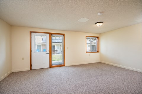 an empty living room with a door to a patio