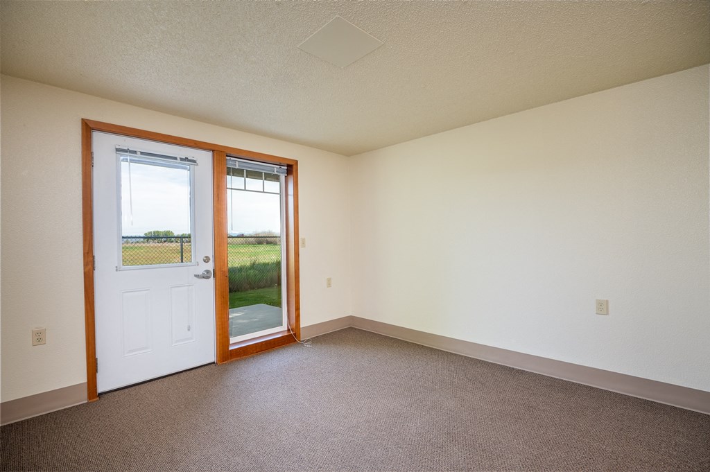 an empty living room with a door to a patio