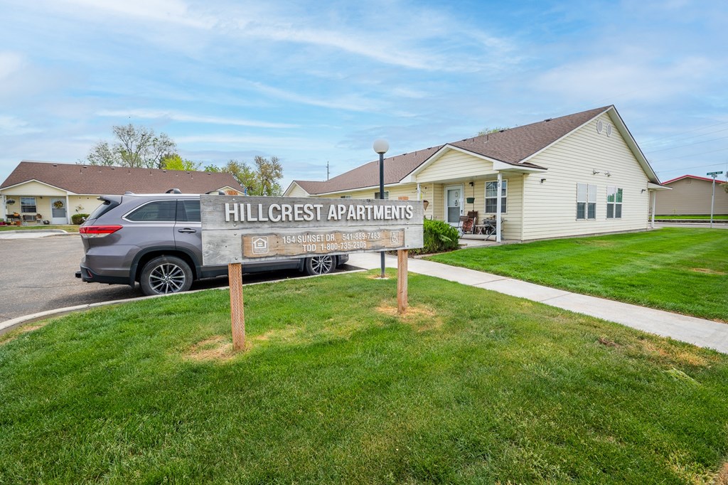 the hillcrest apartments sign in front of a house