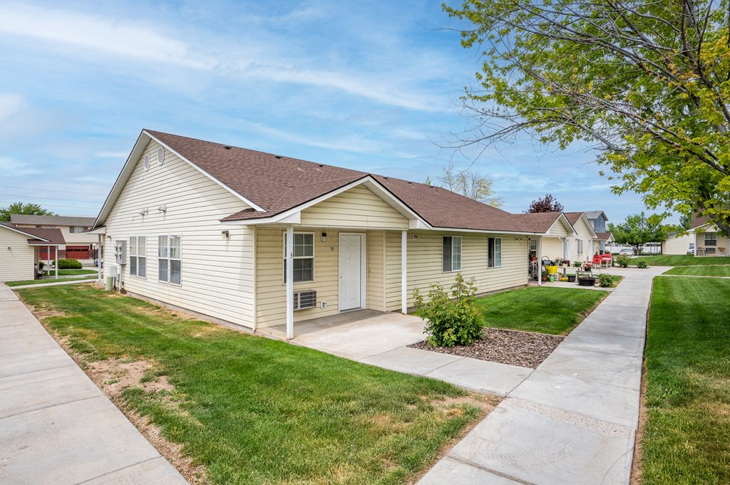 a small white house with a sidewalk in front of it