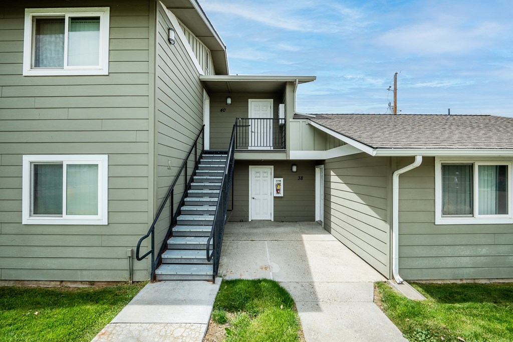 an exterior view of a gray house with stairs and a porch