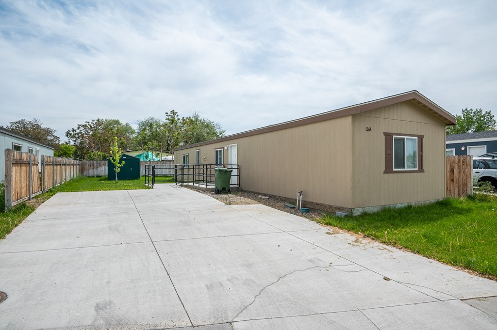 a beige house with a driveway and a fence