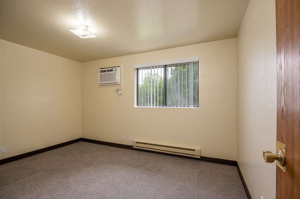 the interior of an empty room with a window and a door