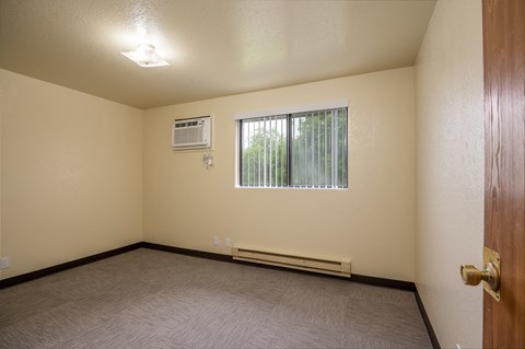 the interior of an empty room with a window and a door