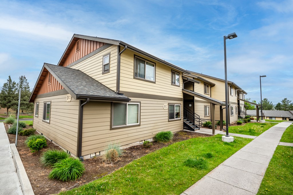 a row of houses on the side of a sidewalk