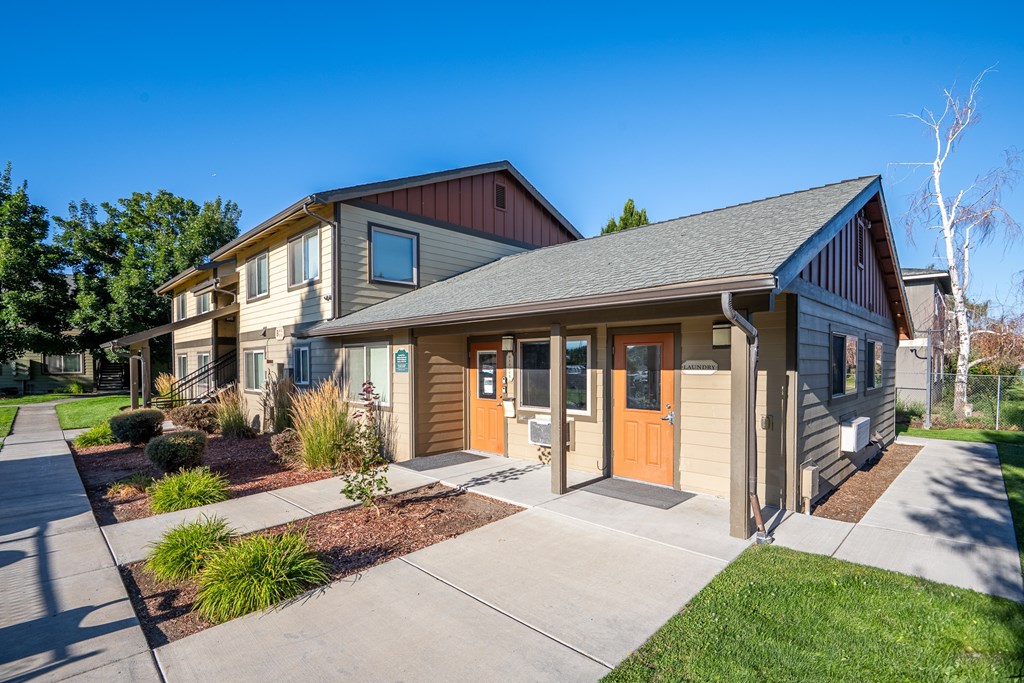 A modern house with a brown roof and a grey siding.