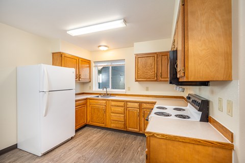 A kitchen with wooden cabinets and a white refrigerator.
