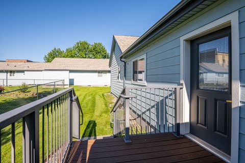 A house with a grey exterior and a brown deck.
